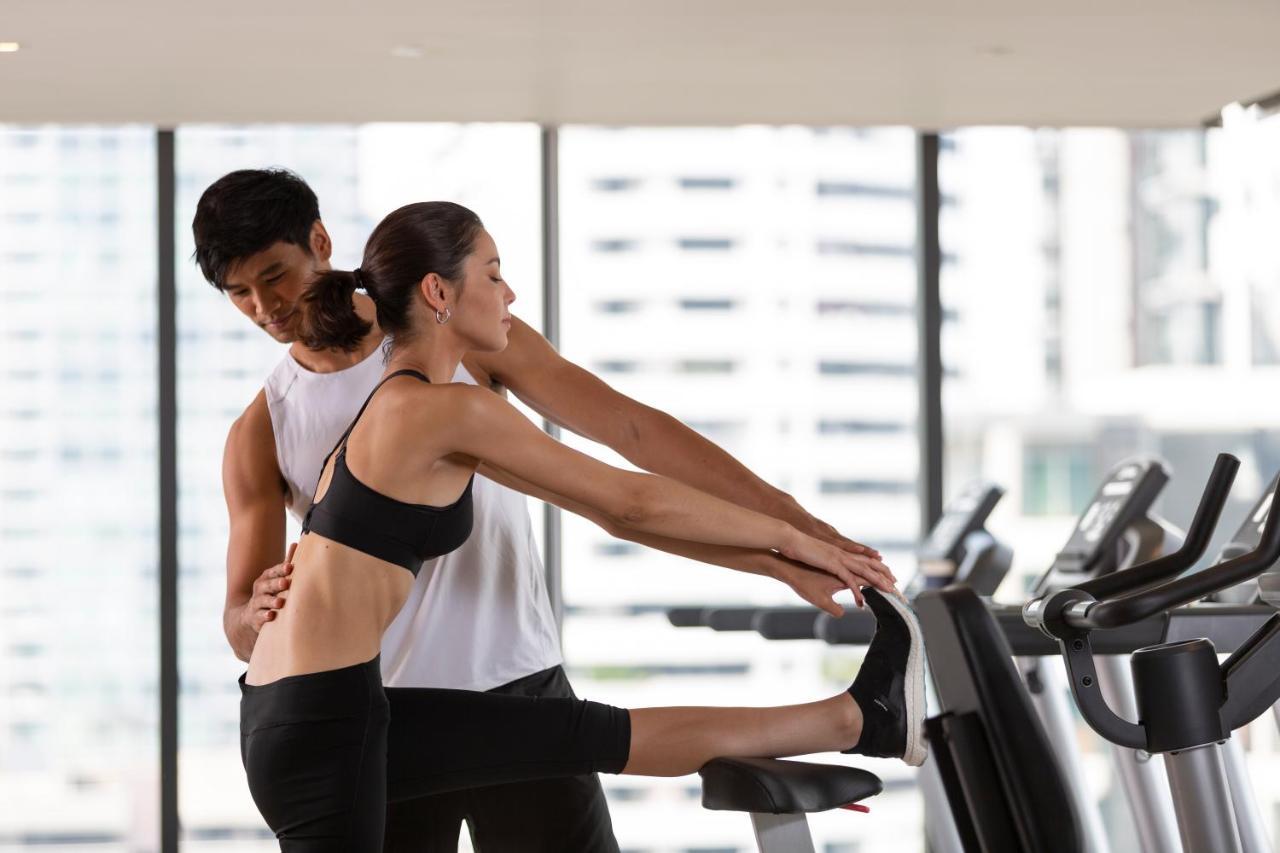 Ascott Thonglor Bangkok酒店 外观 照片 A personal trainer assisting a woman with a stretching exercise